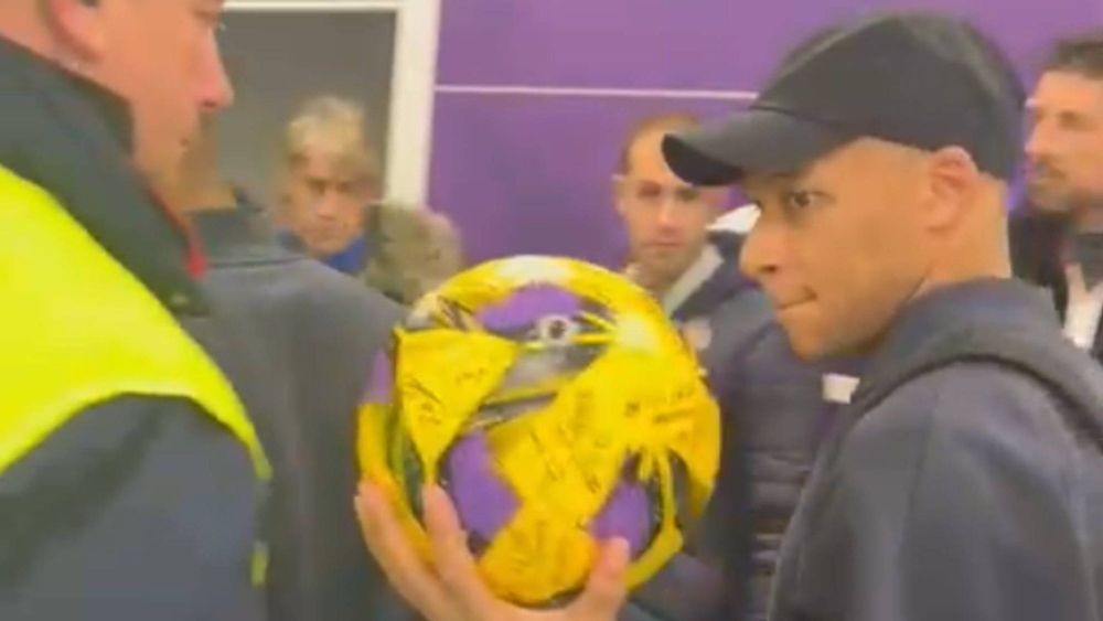 Mbappé saliendo del estadio con el balón firmado