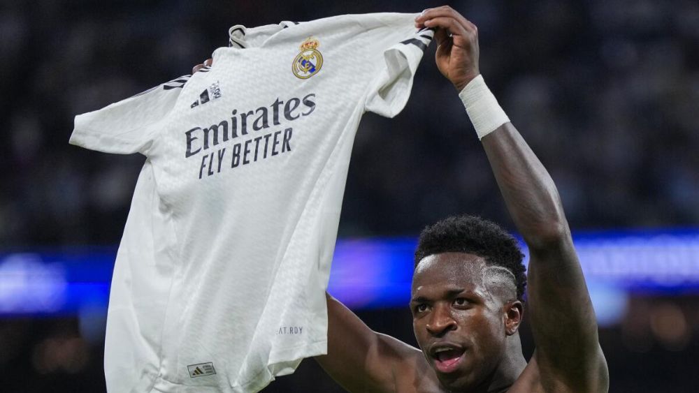 Vinicius, mostrando la camiseta del Real Madrid durante la celebración de un gol con el equipo en esta temporada.